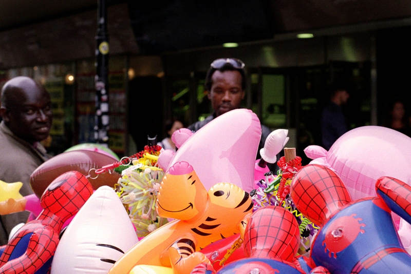 Photograph of colourful inflatable toys with two men in the background